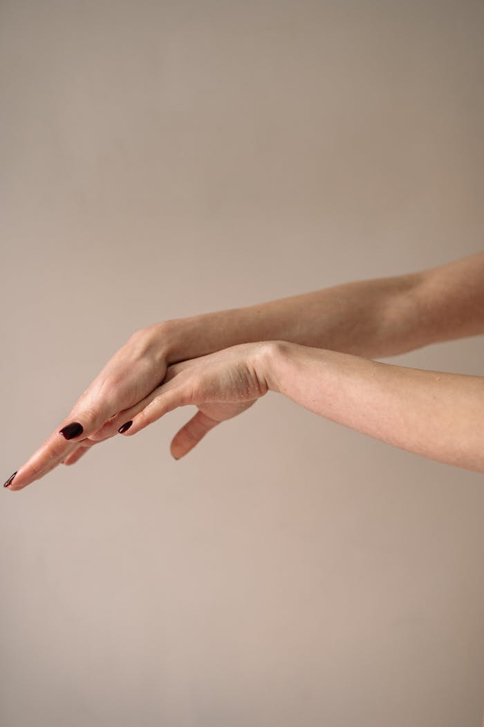 Close-up of elegant female hands with a neutral background, showcasing beauty and finesse.